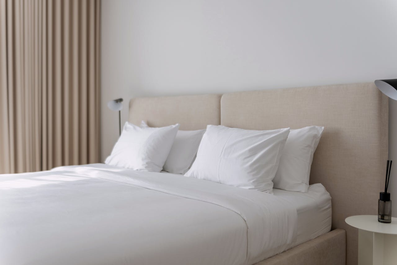 Elegant neutral-toned bedroom with plush bedding, perfect for vacation rentals or Airbnb listings.