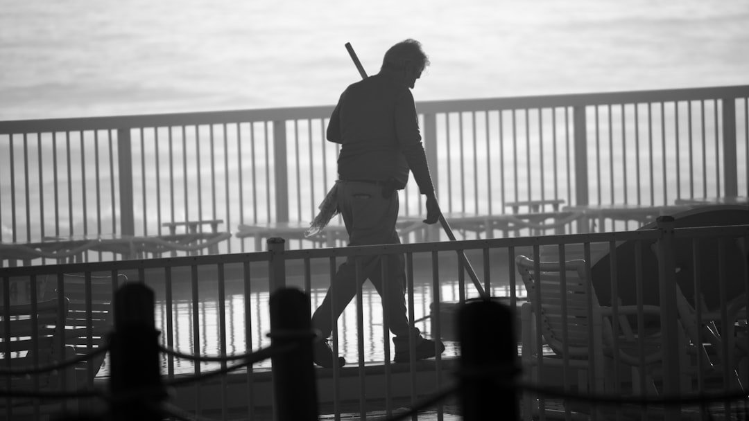 pool attendant cleans pool water at beachfront condo in early morning